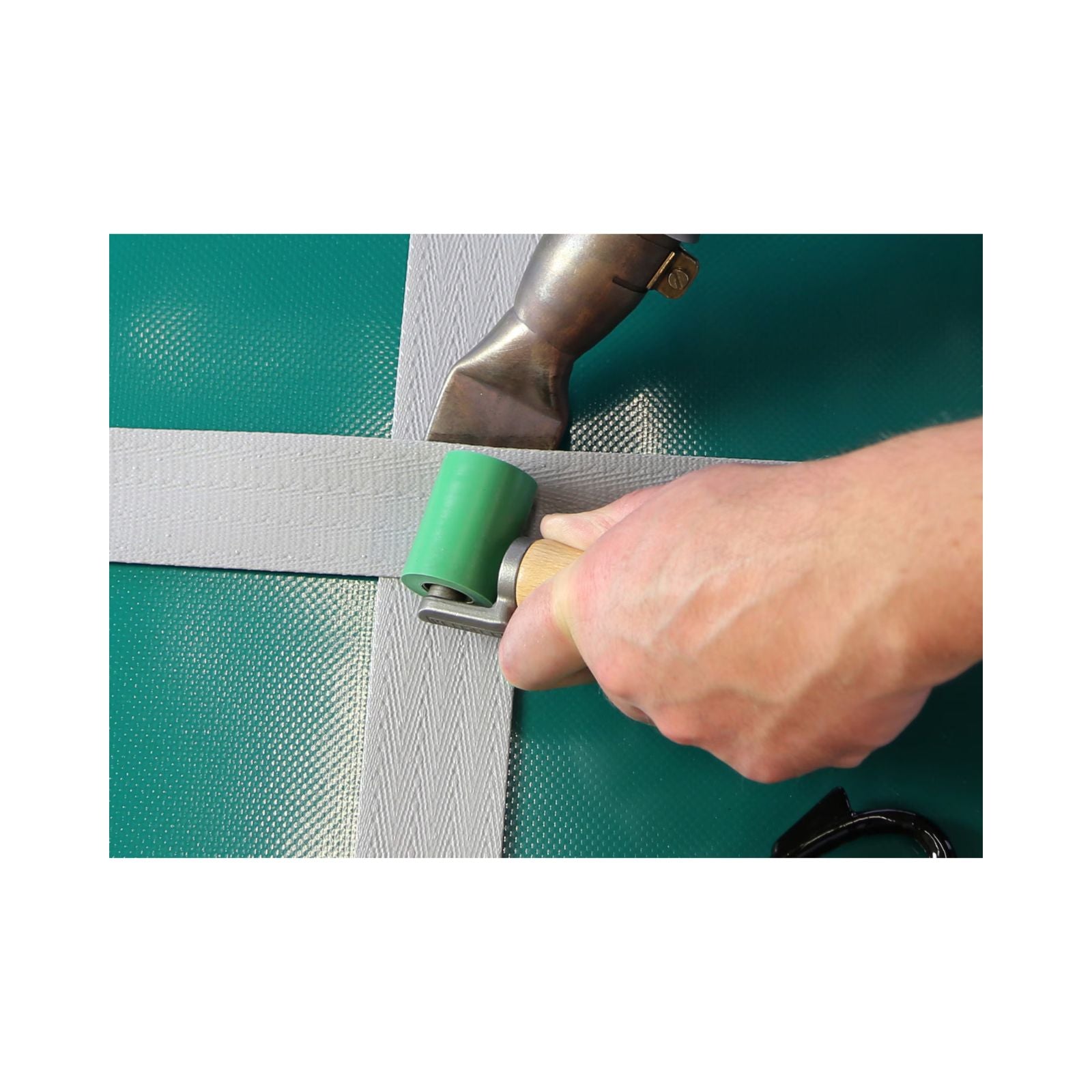 Hand using a tool to repair a green mesh screen
